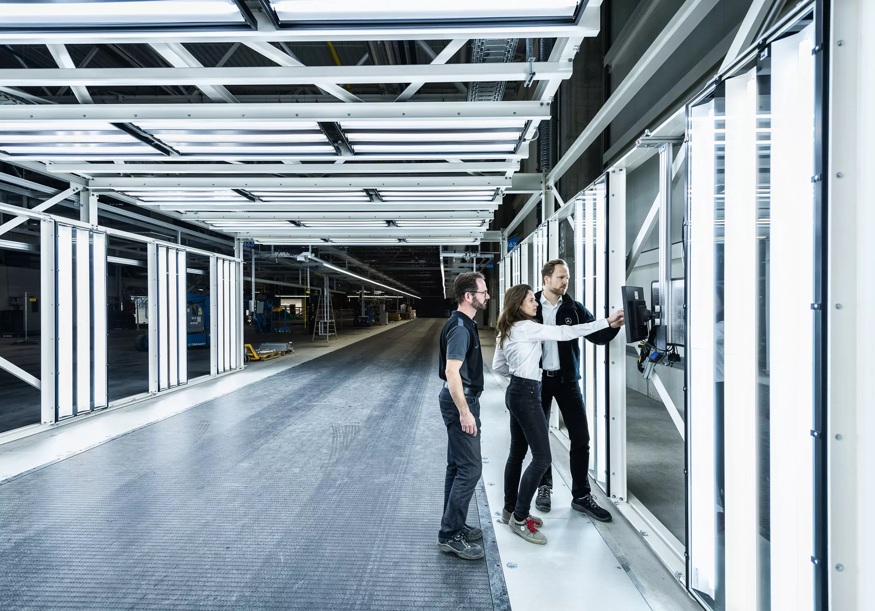 3 Personen an einem Bedienfeld im Lichttunnel